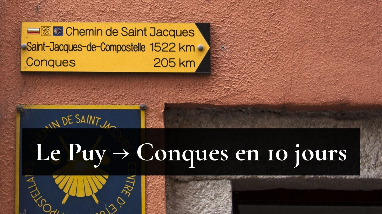 Panneau jaune du GR65 dans la rue Saint-Jacques du Puy-en-Velay : Conques 205 km, Saint-Jacques-de-Compostelle 1 522 km, au-dessus d'une plaque à la coquille