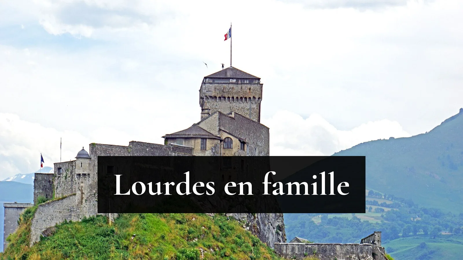 Le château fort de Lourdes sur son rocher, avec les Pyrénées en arrière-plan