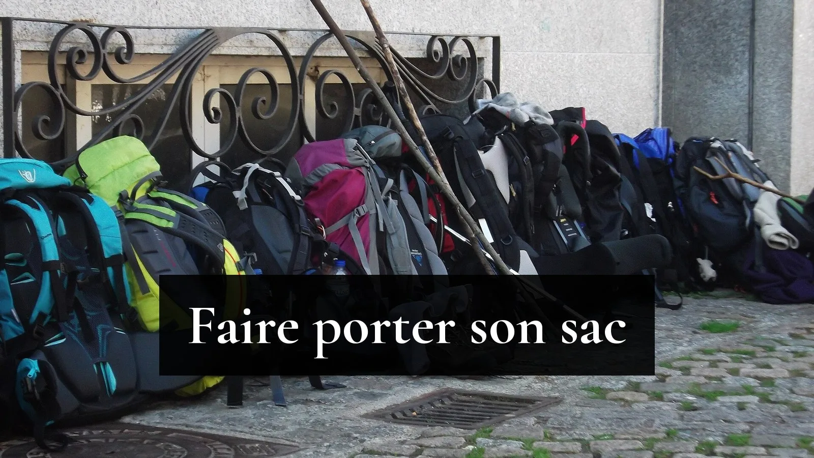 Sacs à dos de pèlerins alignés contre une grille sur le chemin portugais, à Caldas de Reis